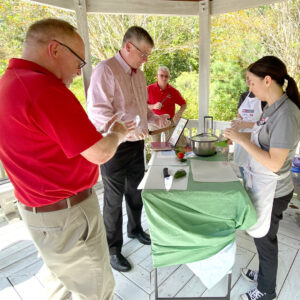 Onslow County EFNEP Educator (Paige S.) showing Dean Fox and Extension Director David Monks the pitch grip technique.
